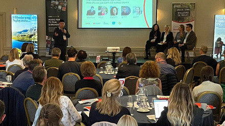 Photo of a full conference room at Content Without Borders, the audience is watching a panel discussion at the front of the room.