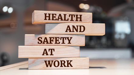 Photo image of a stack of Jenga-like wooden bricks with the words Health and Safety carved into them.