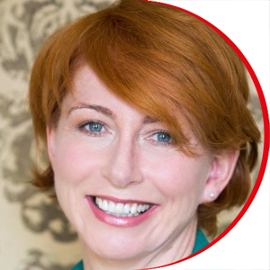 Headshot: Jane Kelly - a woman with short red hair and blue eyes, wearing a blue/green jacket and top.