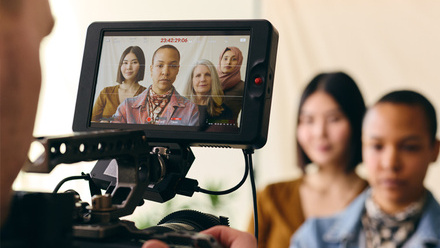 Photo taken behind a camera monitor showing four women of different ethnic backgrounds looking directly into the camera.