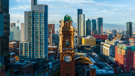 Image of downtown Manchester with a mix of modern and old buildings and the iconic Kimpton clocktower in the centre.