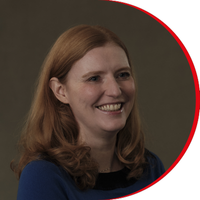 Headshot: Laura Crowley - a woman with long red hair wearing a royal blue top.