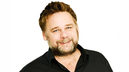 Headshot: Richard Bond, a man with short, fair quaffed hair and beard, wearing a black shirt.