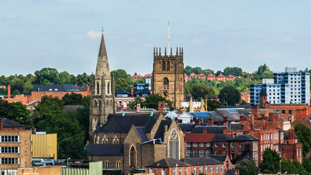 Photo of Nottingham skyline showing housing, apartment buildings, churches and office blocks.