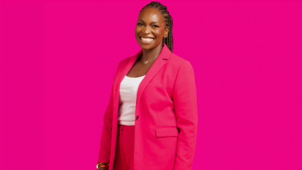 Photo of High Potential Talent Summit organiser, Arit Eminue, a woman with long brown braided hair wearing a bright suit with a white t-shirt.