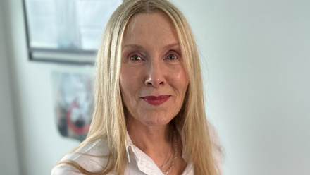 Headshot: Jane Muirhead, a woman with long, straight blonde hair wearing a white shirt.