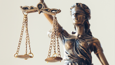 Photo close up of a bronze Lady of Justice statue.