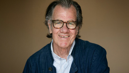 Headshot: Peter Hamilton, an older man with grey/black hair combed back, wearing brown glasses, a blue jacket and light shirt.