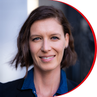 Headshot: Nicky Bentham, a woman with short wavy brown hair, wearing a navy blue shirt and black jacket.