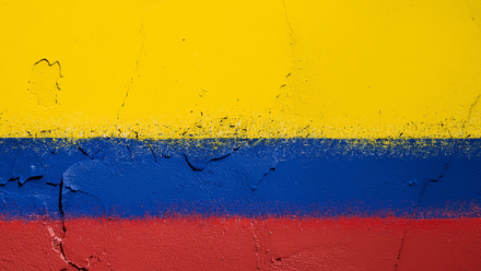 Colombian Flag colours - yellow, blue and red - painted on a rough wall surface.